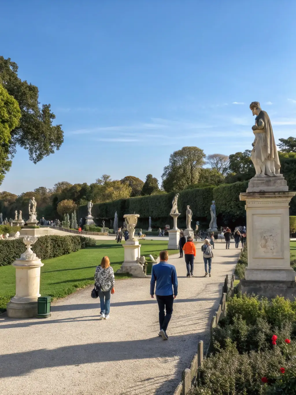 A photograph showing a diverse group of people exploring an open-air art exhibition at Domaine de Beaulieu, with various sculptures and installations visible in the background.