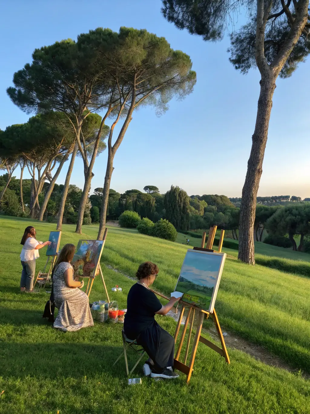 A photograph capturing a group of visitors participating in an outdoor art workshop at Domaine de Beaulieu, with easels set up amidst the sculptures and greenery.